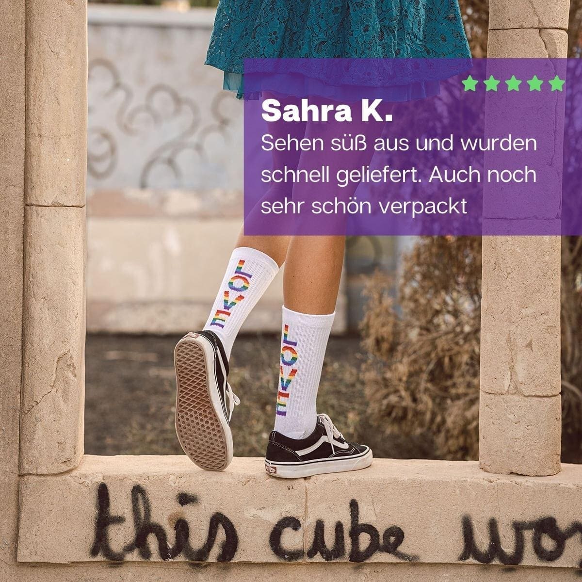 Mädchen stehend mit weißen Pride Tennissocken und buntem LOVE Schriftzug von PATRON SOCKS