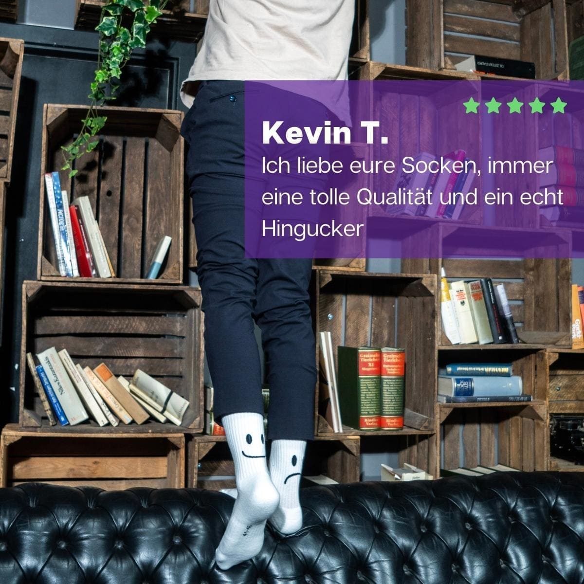 Mann stehend am Buchregal mit weißen Sportsocken mit Smile Motiv von PATRON SOCKS