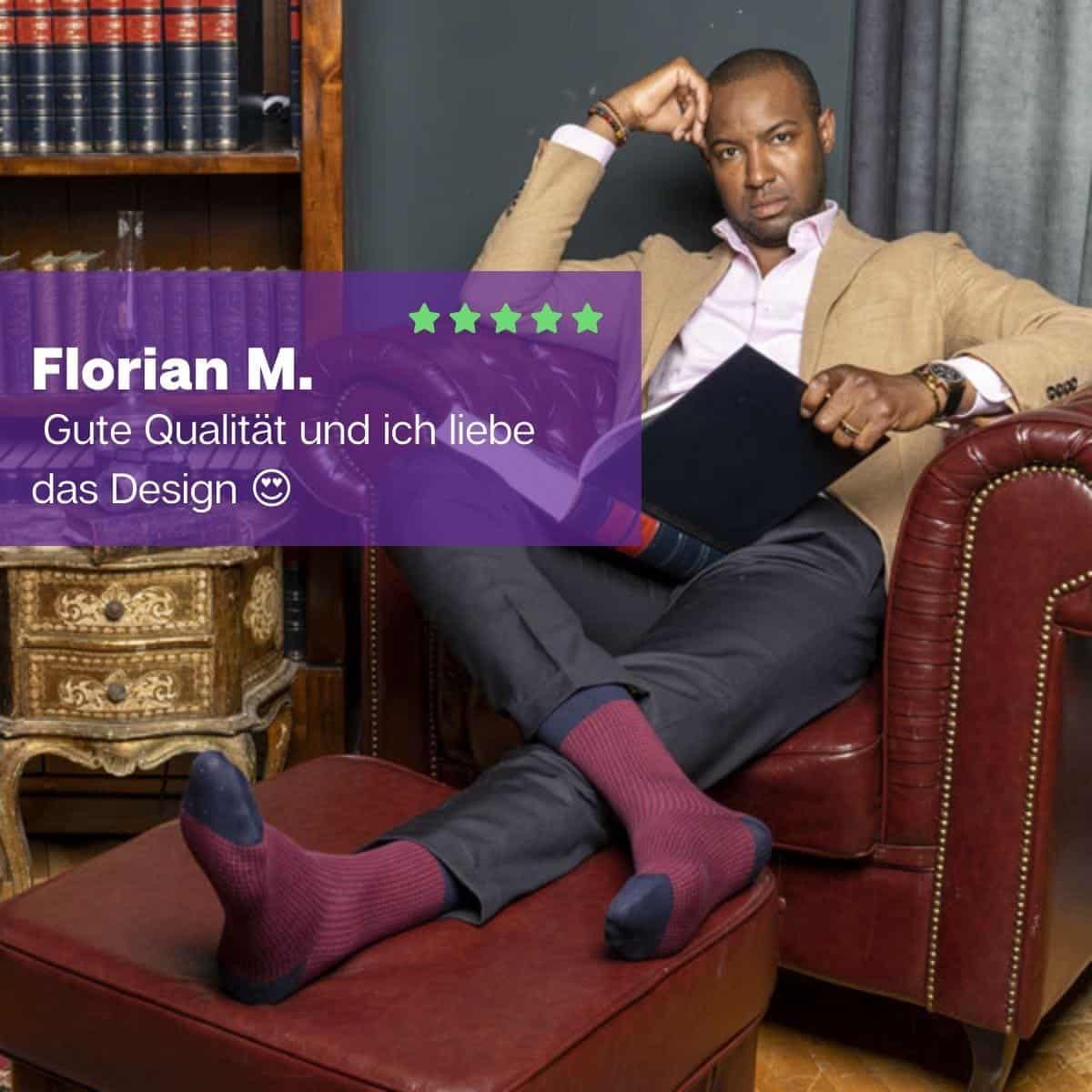 Elegant gekleideter Mann im Sessel liegend, bekleidet mit rot blauen Luxus Herren Socken von PATRON SOCKS