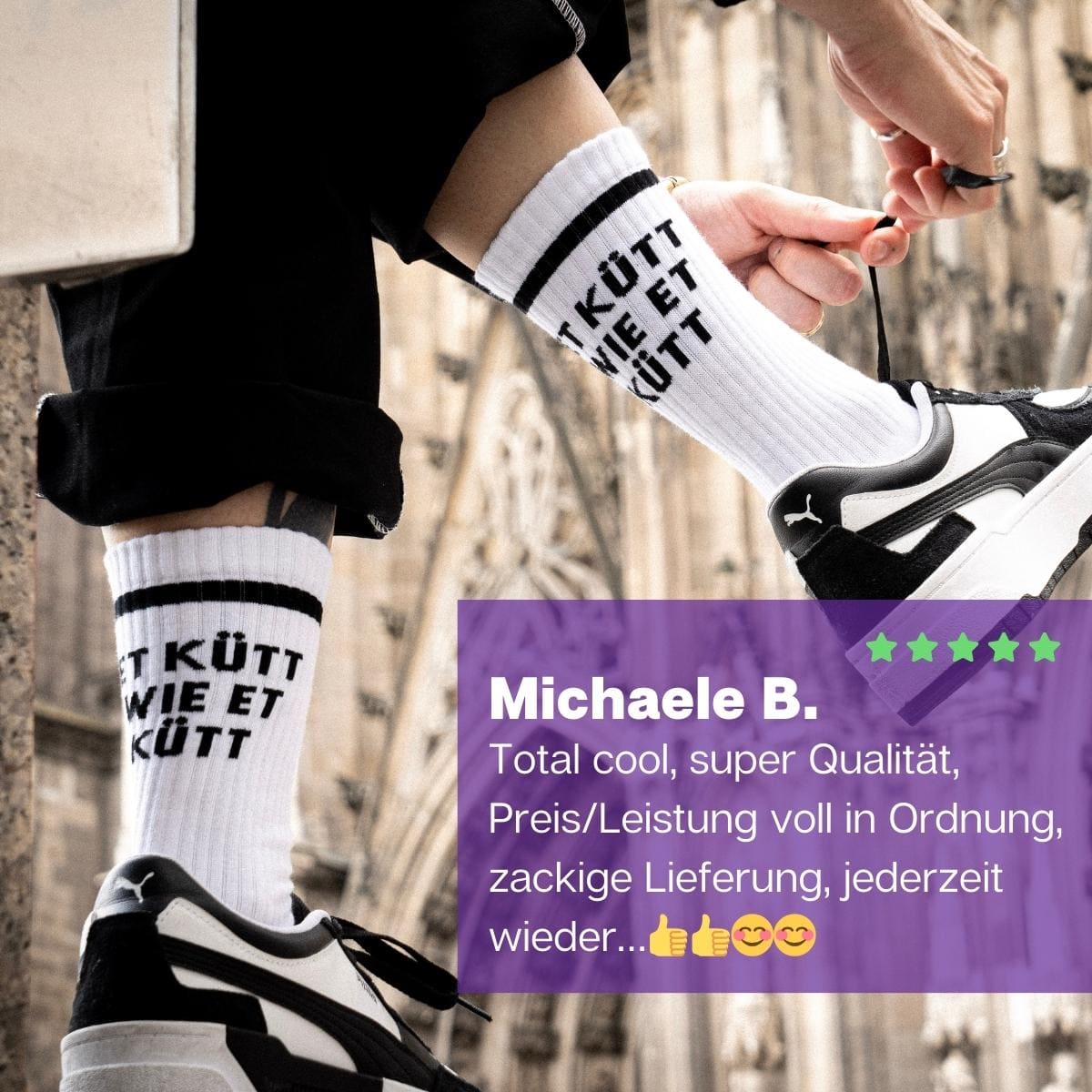 Füße in schwarz weißen Turnschuhen mit weißen Sportsocken und schwarzem Et kütt Schriftzug von PATRON SOCKS