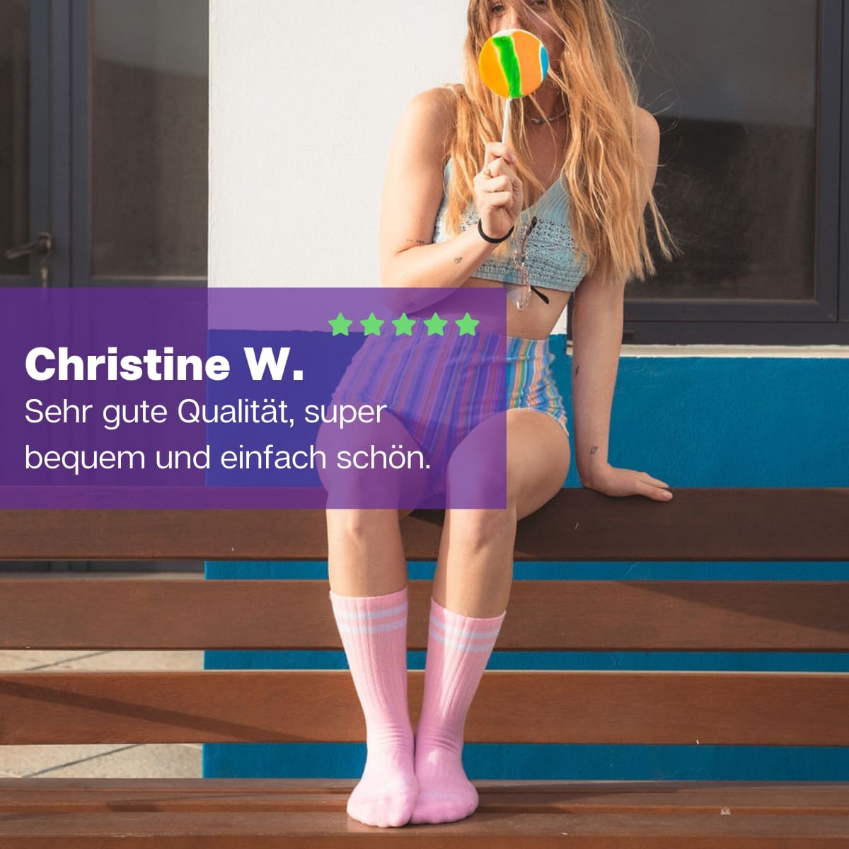 Frau sitzend auf einer Bank mit einem Lolli trägt rosa Sportsocken mit weißen Streifen von PATRON SOCKS 